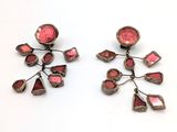 une paire de boucles d'oreilles roses et argentées posées sur un fond blanc