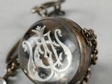 a close up of a necklace with a dragon on it