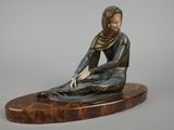 statue en bronze représentant une femme assise sur un socle en marbre