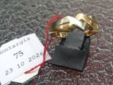 a gold ring on a black stand with a price tag