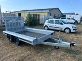 the trailer is parked on the grass in front of a building