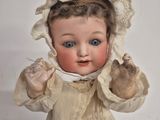a doll that is wearing a dress and a bonnet