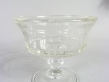 a clear glass bowl on a table with a white background