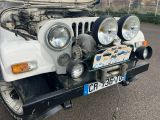 a white jeep that is parked in a parking lot