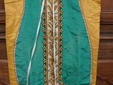 une robe verte et jaune accrochée à une porte en bois