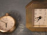 two clocks sitting next to each other on a table