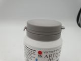 a bottle of white paint sitting on a white surface