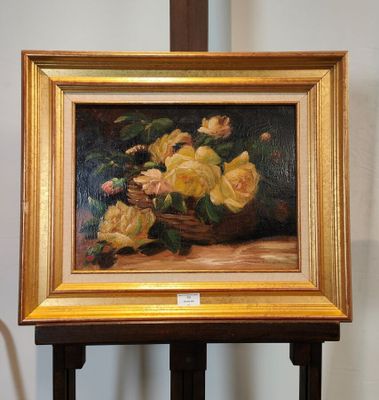 un tableau représentant des roses jaunes dans un panier, posé sur un chevalet