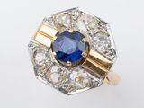Gros plan sur une bague en saphir et diamants posée sur une surface blanche