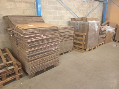 several pallets of cardboard are stacked on pallets in a warehouse