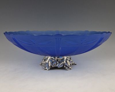 a close up of a blue glass bowl on a metal stand