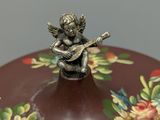 a small figurine sitting on top of a decorative box