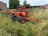 a red tractor that is sitting in the tall grass