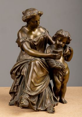 bronze statue of a woman reading to a child on a table