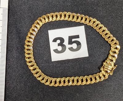 une photo d'un bracelet en chaîne dorée sur lequel figure le chiffre 35