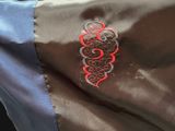 a brown and blue jacket with a red design on it