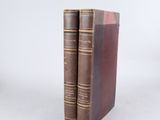 deux vieux livres posés l'un sur l'autre sur une surface blanche