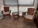 two wicker chairs and a table in the corner of a room