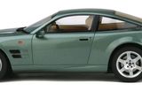 a green toy car that is sitting on a white surface