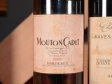 two bottles of wine sitting on a table next to each other