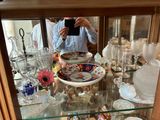 un homme en train de prendre une photo d'une vitrine remplie d'objets en verre