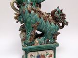 statue of a green dragon on a pedestal with a white background
