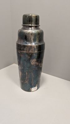 un vase en argent posé sur une table blanche