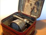 a small tin box with a clock inside of it