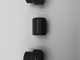 a close up of three black pipe fittings on a white surface