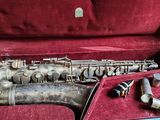 a silver saxophone in a red case on a table