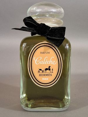 a bottle of perfume with a black bow on it