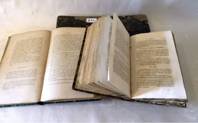 trois livres ouverts posés les uns sur les autres sur une table