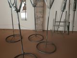 four metal stands that are on the floor in a room