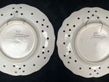 pair of white plates with black dots on them on a black surface