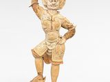 statue d'un homme tenant un oiseau sur la main, avec une balle rouge au premier plan