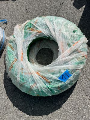 un sac de fil de fer et un rouleau de fil de fer posés par terre