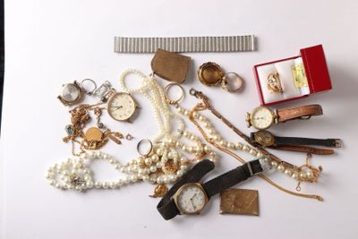 a lot of jewelry on a white surface with a ruler