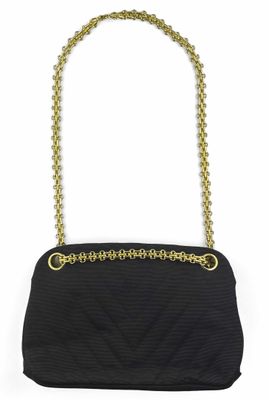 un sac à main noir muni de poignées en chaîne dorée et d'une bandoulière en chaîne