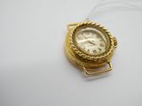 une montre en or entourée d'une chaîne sur une surface blanche