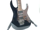 a black electric guitar on a stand on a white background