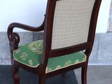 a wooden chair with a green cushion on a black and white checkered floor