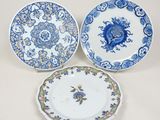 trois assiettes bleues et blanches ornées de motifs floraux