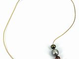 the necklace has two pearls on it and a gold chain