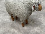 a sheep that is standing on the concrete floor