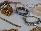 many different types of bracelets and rings on a table