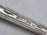 a silver spoon with writing on it sitting on a table
