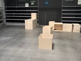 une grande pièce où s'entassent de nombreuses boîtes par terre
