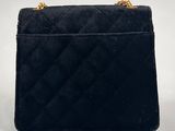 a black velvet bag with a gold chain strap