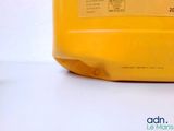 a yellow container of liquid sitting on a white surface