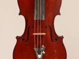 un vieux violon posé sur une table près d'un mur blanc